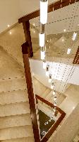 The stair set into a tight triangular space. The chandelier adds drama to the space.